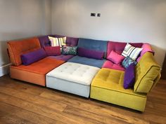 a multicolored sectional couch with pillows on it