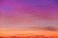 an orange and purple sunset with clouds in the sky