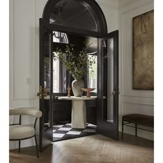 an entry way with black and white checkered flooring, potted plant in the center