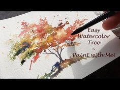 someone is painting a tree with watercolor on paper