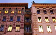 two tall buildings with windows and decorations on the side of them at dusk or dawn