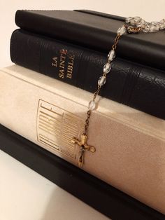 three books stacked on top of each other with a chain attached to the book ends