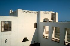 a white building with many windows and shutters