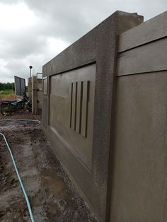 there is a concrete fence that has been placed on the ground with water hoses attached to it