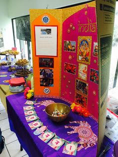 a purple table topped with lots of plates and bowls next to a sign that says el sion