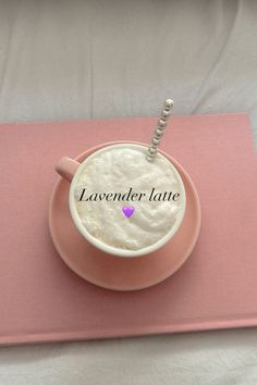 a pink plate with a drink in it on top of a white sheet that says lavender latte