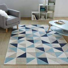 a living room with a blue and white rug on the floor next to a gray chair