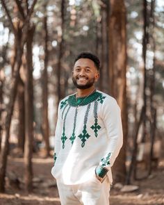 a man standing in the woods wearing a green and white outfit