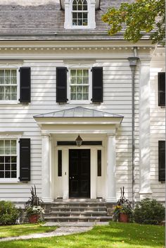 a white house with black shutters and windows