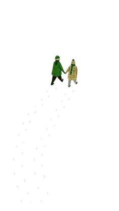 two people in green coats are walking up a hill