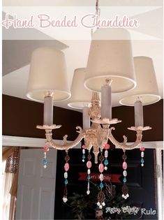 a chandelier hanging from the ceiling in a living room with two lamps on it