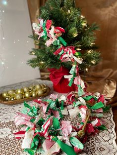 a small christmas tree sitting on top of a table next to a pile of candy canes