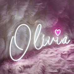 the word ollivia written in white neon lights on a pink background with feathers