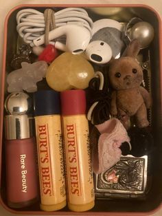 an open box filled with various items like lipstick, hairbrushes and stuffed animals