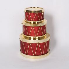 three tiered red and gold cake stand on white background with space for text or image