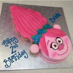 a birthday cake with pink frosting and an angry bird on it's face