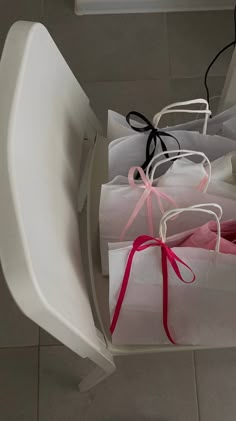 several bags are sitting on a chair and tied with ribbons in order to be used as gifts