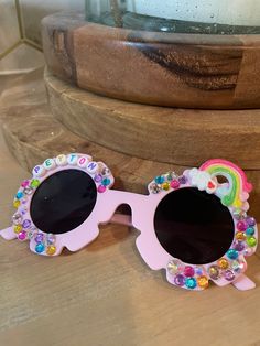 Personalized sunglasses, made to order. Perfect for a birthday party to be used as favors or as a gift for a little girl or flower girl! Fit best on children ages 2-12.  Each order comes with a sunglass sleeve. Each pair will include multiple embellishments depending on the length of child's name and availability of rainbow colors. Please send a note if you would like personalization to be arranged a certain way, otherwise all glasses will vary slightly.  This pair is on purple glasses, but colo Fun Pink Sunglasses For Gift, Fun Pink Handmade Sunglasses, Cute Customizable Sunglasses For Gift, Handmade Fun Pink Sunglasses, Fun Handmade Pink Sunglasses, Fun Handmade Sunglasses As A Gift, Playful Personalized Pink Sunglasses, Pink Tinted Sunglasses As Gift, Novelty Pink Sunglasses With Uv Protection