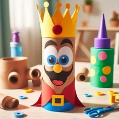 a paper crown sitting on top of a wooden table next to crafting supplies and toys