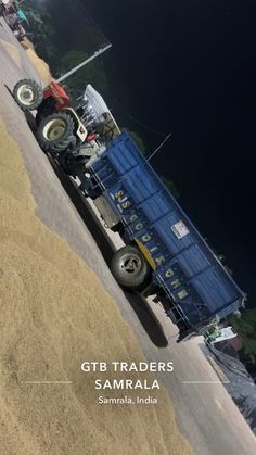 a tractor trailer parked on the side of a road next to a body of water