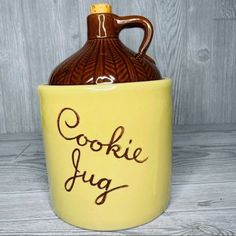 a cookie jar with the word cookie jug written on it in brown and yellow lettering