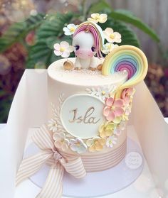 there is a small cake decorated with flowers and a unicorn on it's top