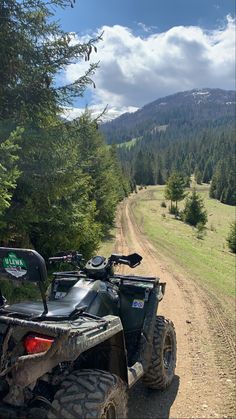 an atv parked on the side of a dirt road