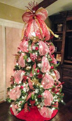 a christmas tree decorated with red and white ribbons, bows and candy canes is shown in an instagram