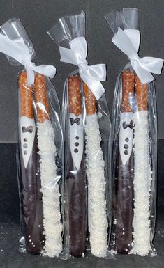 three carrots wrapped in plastic and tied with white ribbon