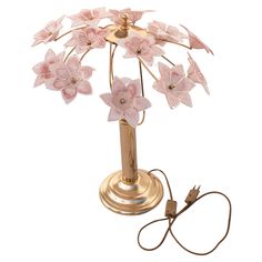 a lamp with pink flowers on it is plugged into a charger for charging