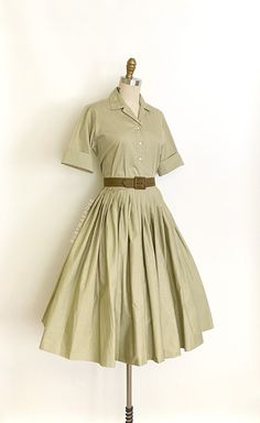 "vintage dress  Era: 1950's Label: Miss Pat. California. Sanforized. Closure: top * button front, skirt * side metal zipper, button waist Material: cotton Colour: muted olive green  Details: versatile two piece top and skirt set, original matching belt, timeless silhouette, optional turn up cuffs, full pleated skirt Fits like: small * top * Bust: 39\" Shoulders: 14.5\" Waist: 36\" Length: 22\" * skirt * Waist: 26\" Hips: free Length: 28\" (5.5\" hem allowance) Condition: The set feels like its never been worn/possibly deadstock. The top has a tiny spot on the back of the hem. Skirt is in excellent condition. Priced accordingly.   shop policy  * All items are a final sale. No returns, exchanges and, order cancellations are not accepted.  * Ruby Mae Rose is not responsible for lost or stolen Ruby Mae, Matching Skirt Set, Muted Green, Shirtwaist Dress, Skirt And Top Set, Belt Dress, Rose Vintage, 50s Vintage, Skirt Belt