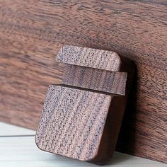 a close up of a piece of wood with a wooden door handle on the side