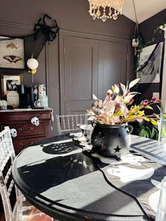 a dining room table with chairs and a potted plant sitting on top of it