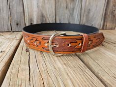 Tan with black antique Navajo pattern leather belt. Hand tooled and embossed on 1.5 inch wide 3.5mm thick quality leather.  The belt is one solid piece of full grain leather, with Chicago screws to be able to change out buckles. This belt is very versatile for work, rodeo, casual, or dressed up for any occasion.  There are 3 fonts to choose from see pictures for reference. Sizes are 28-44 inch. There will be seven holes with the middle hole as the true size.  Please feel free to message me if yo Southwestern Hand Tooled Leather Belt, Southwestern Hand Tooled Leather Belt Buckles, Southwestern Style Hand Tooled Leather Belt, Traditional Leather Belt With Concho, Hand Tooled Leather Belts For Western-themed Events, Rustic Hand Tooled Adjustable Belts, Traditional Hand Tooled Brown Belt, Traditional Hand Tooled Leather Belt Buckles, Rustic Hand Tooled Belt For Western-themed Events