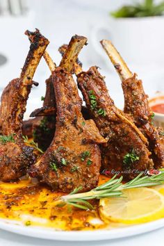 grilled lamb chops on a plate with lemon wedges and garnishes