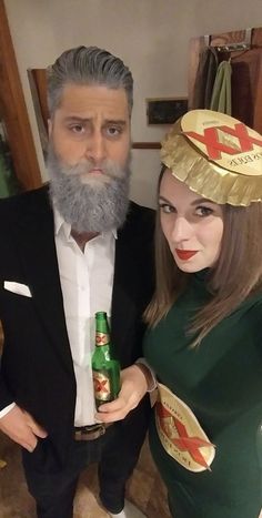 a man and woman dressed up in costumes posing for the camera with beer bottles on their heads