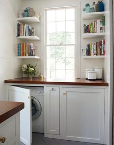 a washer and dryer in a small room with bookshelves on the wall