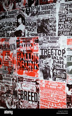 a wall covered with posters and advertisements in red and black