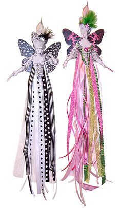 two fairy dolls are standing next to each other on a white background, one is pink and the other is green