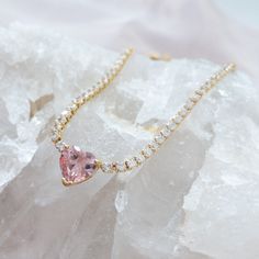 "Shine bright with this sparkly pink heart crystal necklace. This trendy tennis chain necklace is perfect to wear for Valentine's Day and beyond. Get one for yourself or gift it to someone special. DETAILS: ------------ - cubic zirconia studded tennis chain with pink heart pendant - water resistant, gold plated setting - 16 inches + 2 inch extension PACKAGING: ------------------ Your order will be placed in a jewelry box with satin ribbon bow, ready to be given as gift. If you purchase more than Rhinestone Cubic Zirconia Necklaces For Valentine's Day, Pink Cubic Zirconia Heart Necklace, Pink Heart Cut Cubic Zirconia Necklace, Pink Cubic Zirconia Rhinestone Necklace As Gift, Pink Cubic Zirconia Heart Necklace For Wedding, Pink Heart Pendant Jewelry With Rhinestones, Pink Heart-shaped Necklace With Rhinestones, Pink Heart-shaped Rhinestone Jewelry, Pink Heart-shaped Rhinestone Necklace