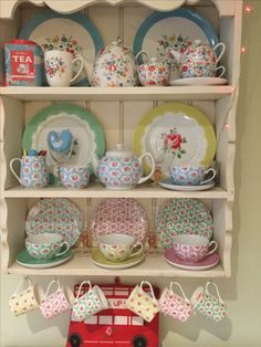 a china cabinet filled with lots of colorful plates and cups on top of it's shelves