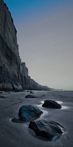 some rocks in the sand and water