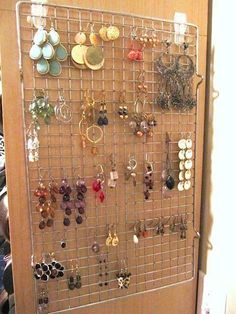 a metal rack with earrings on it in front of a door that has a bunch of earring hooks attached to it