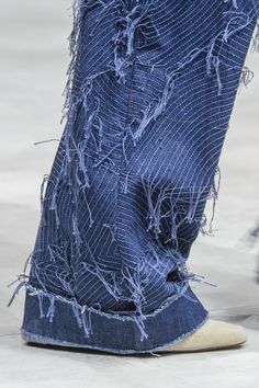 a person's feet with torn jeans on them