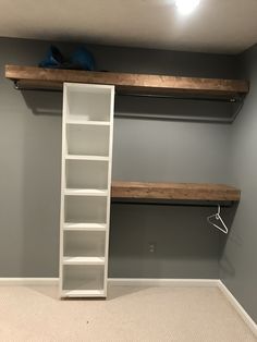 an empty room with shelves and shoes on the shelf next to it in front of a gray wall