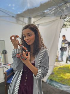 a young woman is holding scissors in her hands