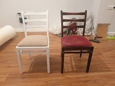 two chairs sitting on top of a hard wood floor next to a roll of paper