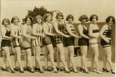 a group of women standing next to each other in bathing suits