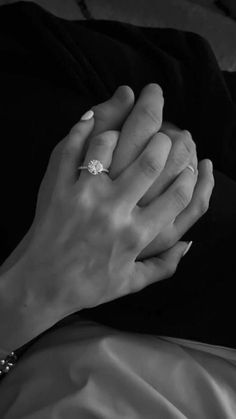 a close up of a person's hands holding the hand of another person wearing a ring