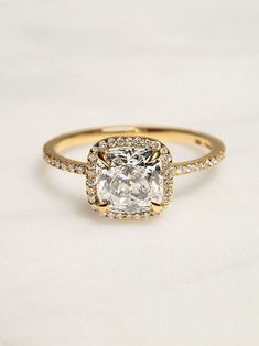 an engagement ring with a cushion cut diamond in the center